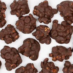 Assorted dark chocolate fudge clusters with nuts, displayed on a vegetarian chocolate background.