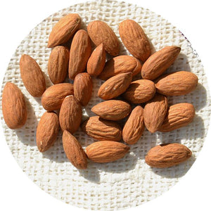 Almonds in a circle on a white cloth.