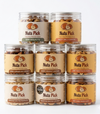 Eight clear jars of The Ultimate Nuts Pick Bundle: 8 Jars of Premium Goodness! are stacked in a pyramid against a white background, creating the perfect premium nut bundle for any occasion.