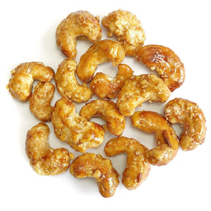 A pile of Honey Ginger Cashews on a white background.