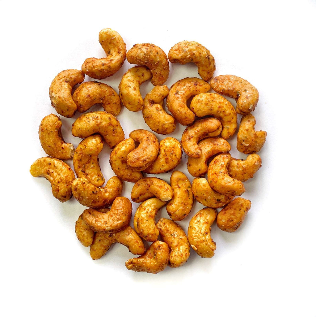 Sweet Chili Cashews sind in einem Kreis auf weißem Hintergrund angeordnet.