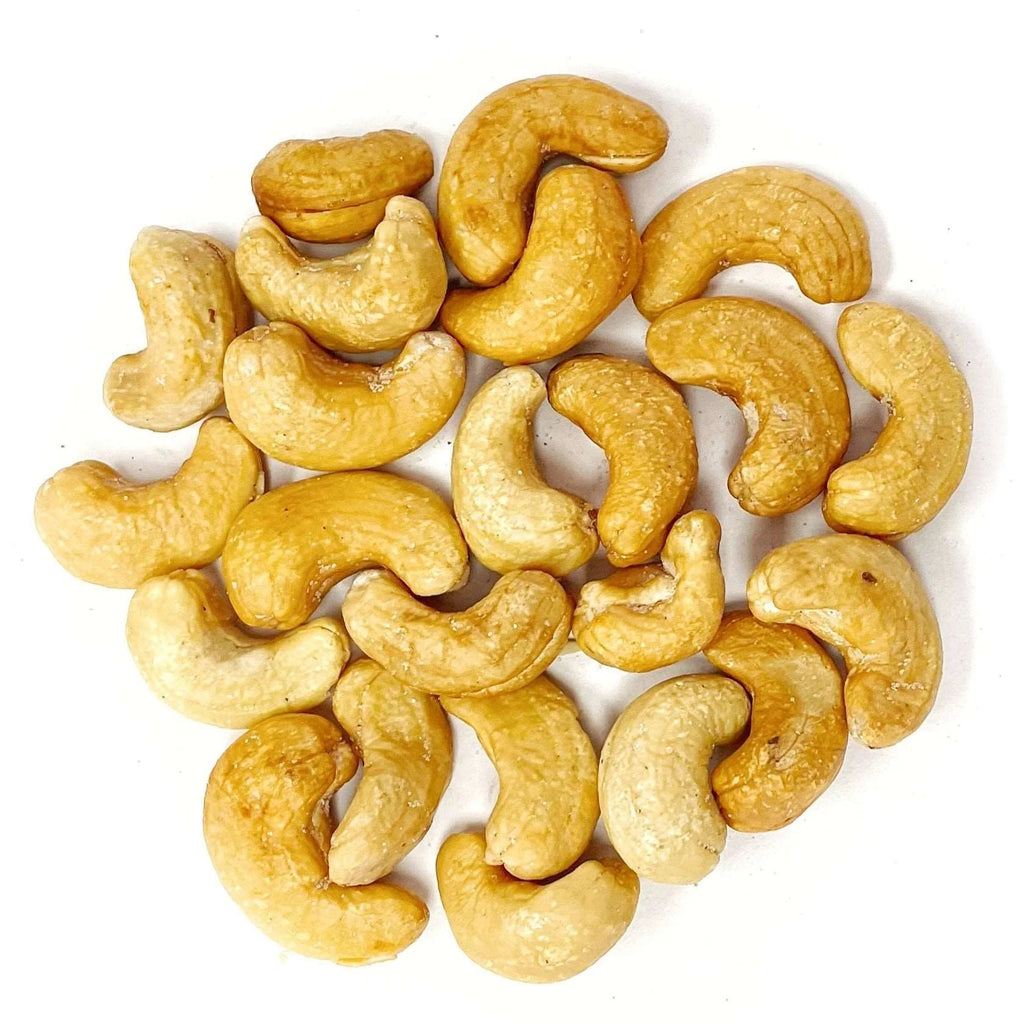 A group of Roasted Salted Cashews Nuts -1kg Bag - LIMITED TIME OFFER arranged randomly on a white surface, showcasing their natural protein.