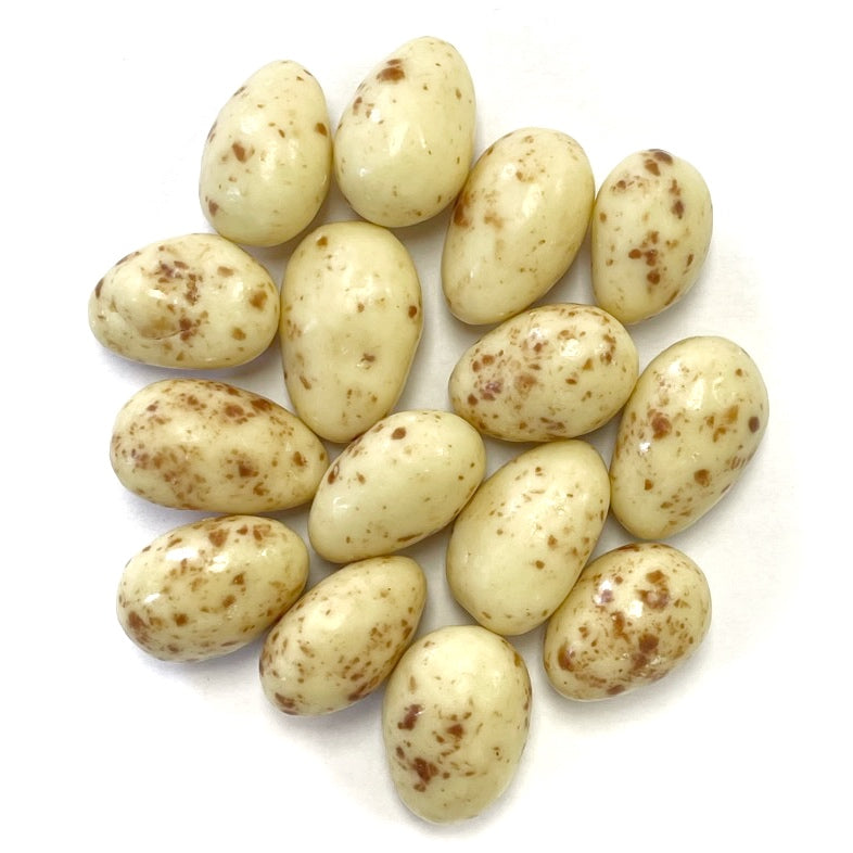 A group of Chocolate Vanilla Almonds on a white surface, with a hint of vanilla aroma.